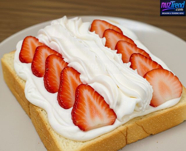 Adding more whipped cream over strawberries in fruit sandwich