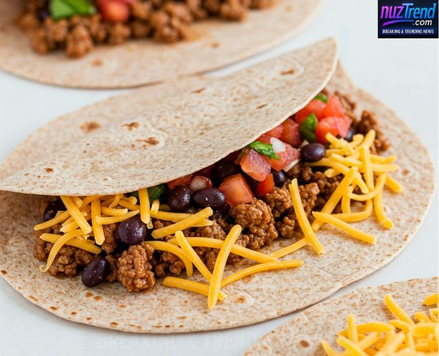 Tortilla with cheese and filling being folded into a burrito