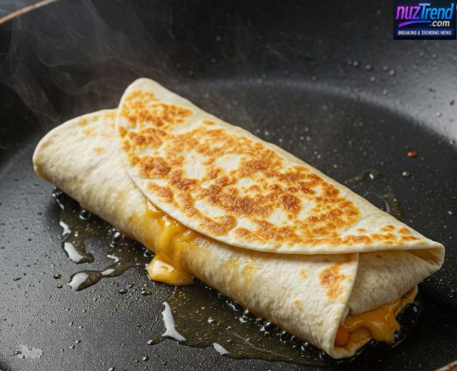 Grilled cheese burrito cooking in a skillet