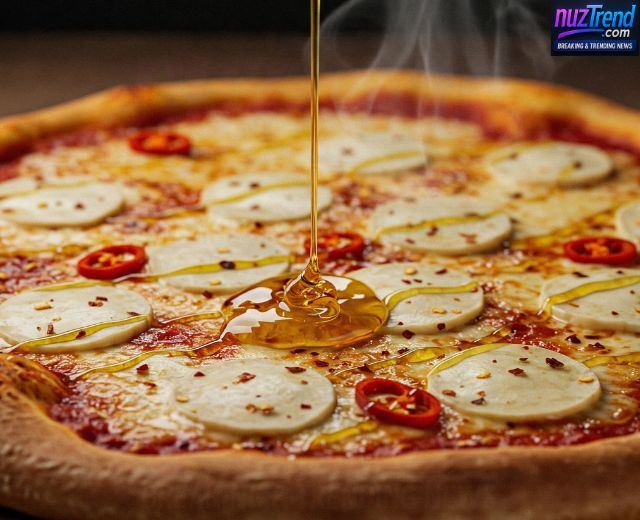 Drizzling hot honey over baked pizza
