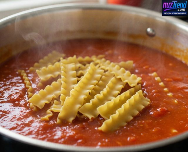 Broken lasagna noodles being added to soup pot