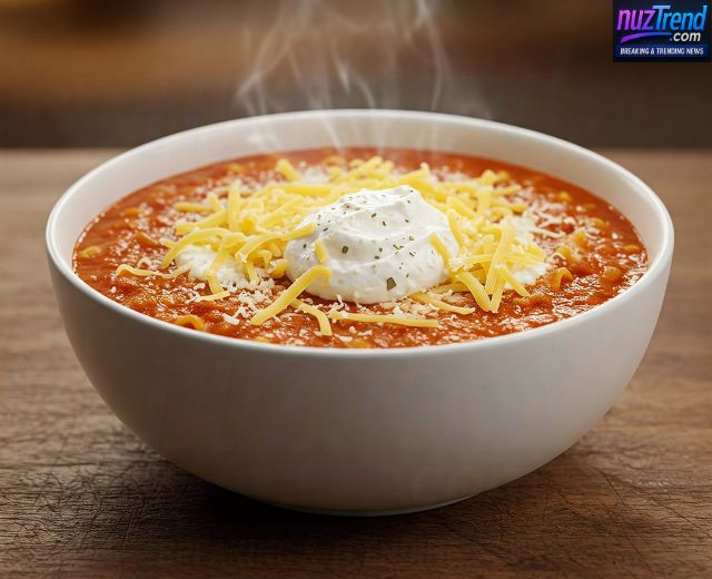 Spoonful of ricotta cheese and mozzarella being added to vegetarian lasagna soup bowl