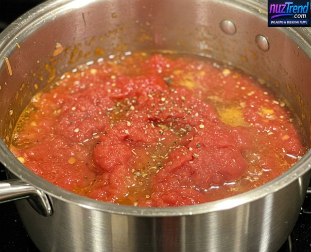 Pouring tomato sauce and vegetable broth into pot with sautéed vegetables