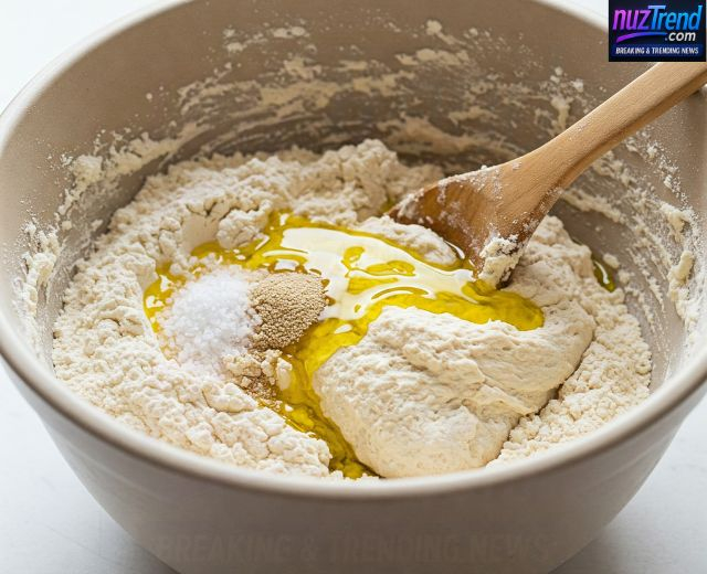Flours, yeast and olive oil being mixed into dough in a bowl