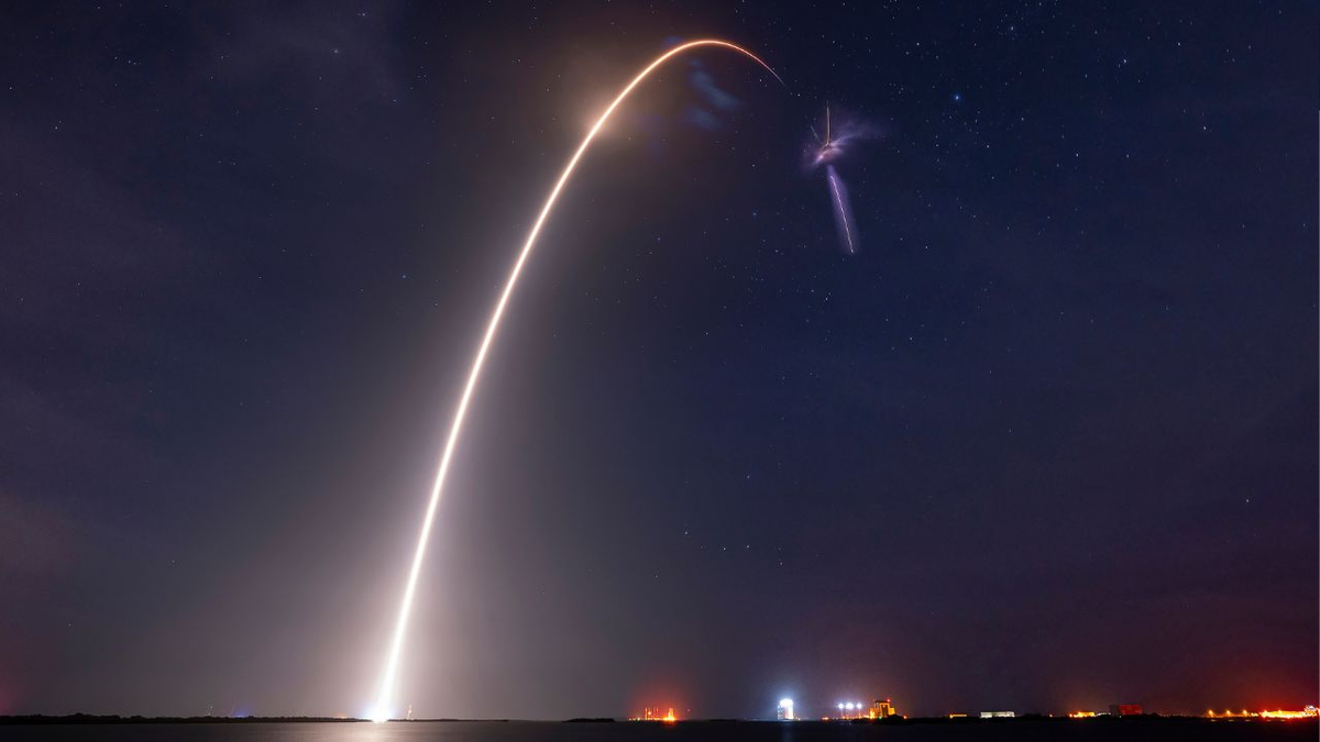 A long-exposure photo shows lift off, second stage ignition, and first stage boostback during SpaceX CRS-32 mission