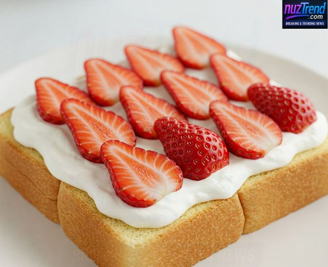 Placing fresh strawberries on whipped cream for fruit sando