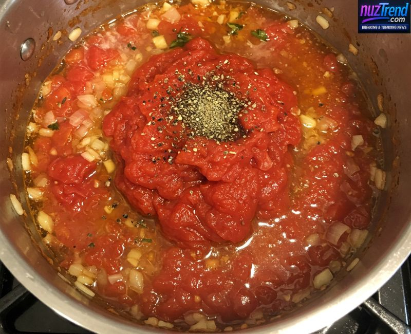 Preparing homemade tomato soup with garlic and herbs