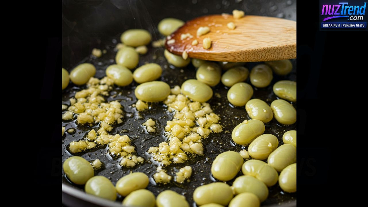 Butter beans being stirred in skillet